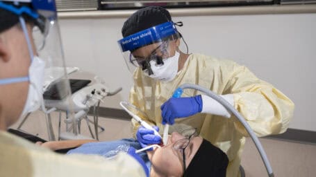A dental hygienist working on a patient