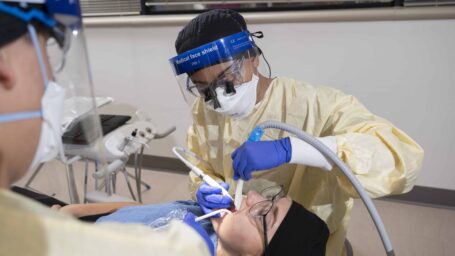 A dental hygienist working on a patient