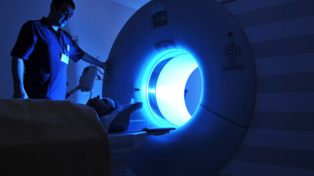 A patient being put into an MRI machine by an radiographer