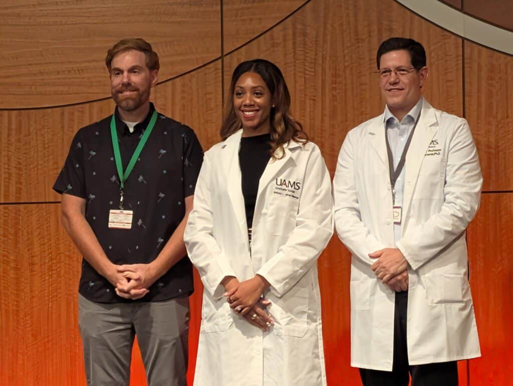 Brittany Wilkerson standing between two adult males on stage