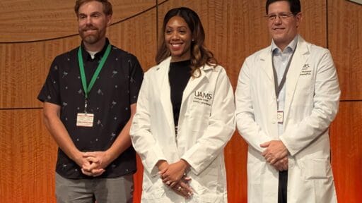 Brittany Wilkerson standing between two adult males on stage