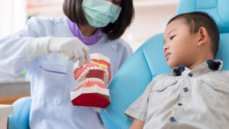 Asian female dentist talking to brush teeth properly explained to the boys were listening to in the hospital