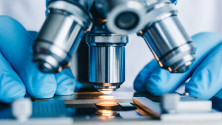 Close-up shot of microscope with metal lens at laboratory.