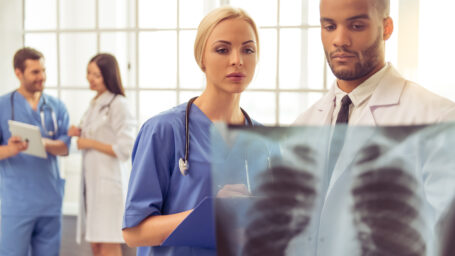 Respiratory therapists look at a scan of a patient's lungs