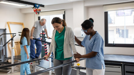 Physical therapist helps a patient walk