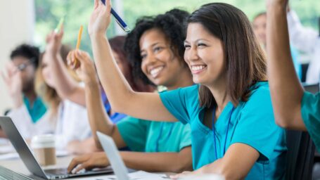 Students raising their hands in class