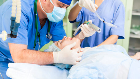 A respiratory therapist intubating a patient